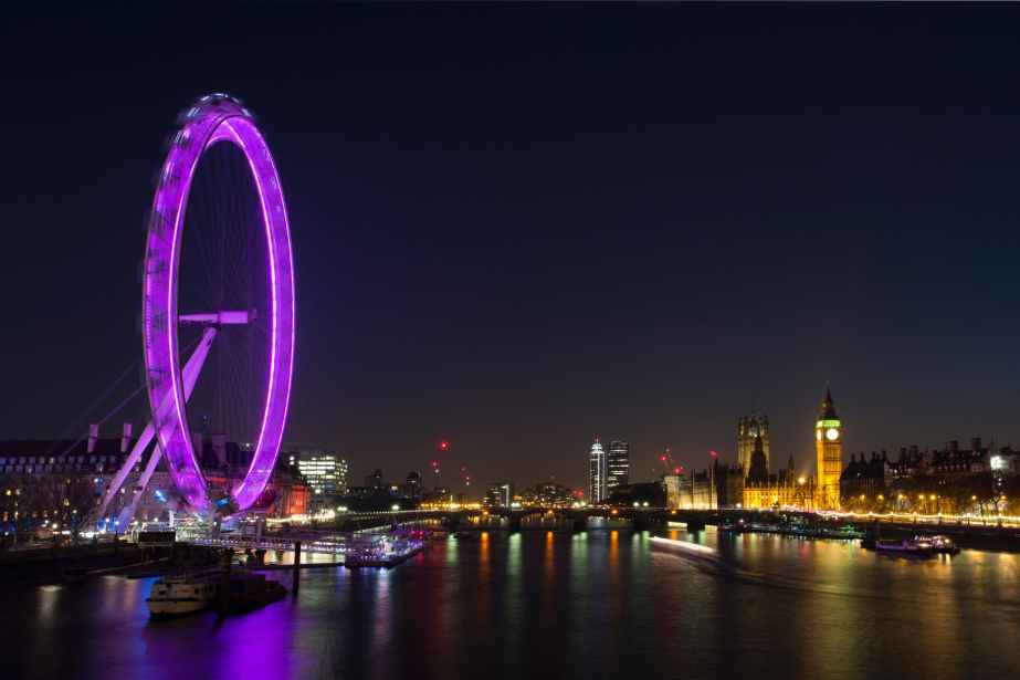 lighted ferrys wheel near body of water during nighttime